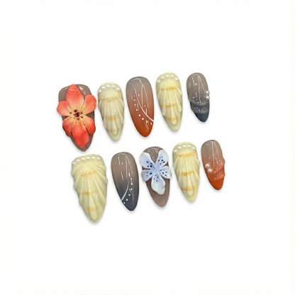 alt="Flat lay of orange and neutral 3D flower almond press on nails with pearl accents"