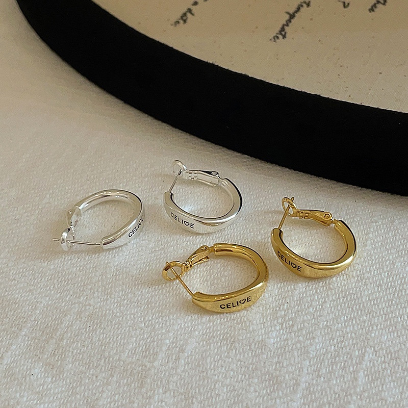 Gold and silver tone hoop earrings arranged on light textured fabric