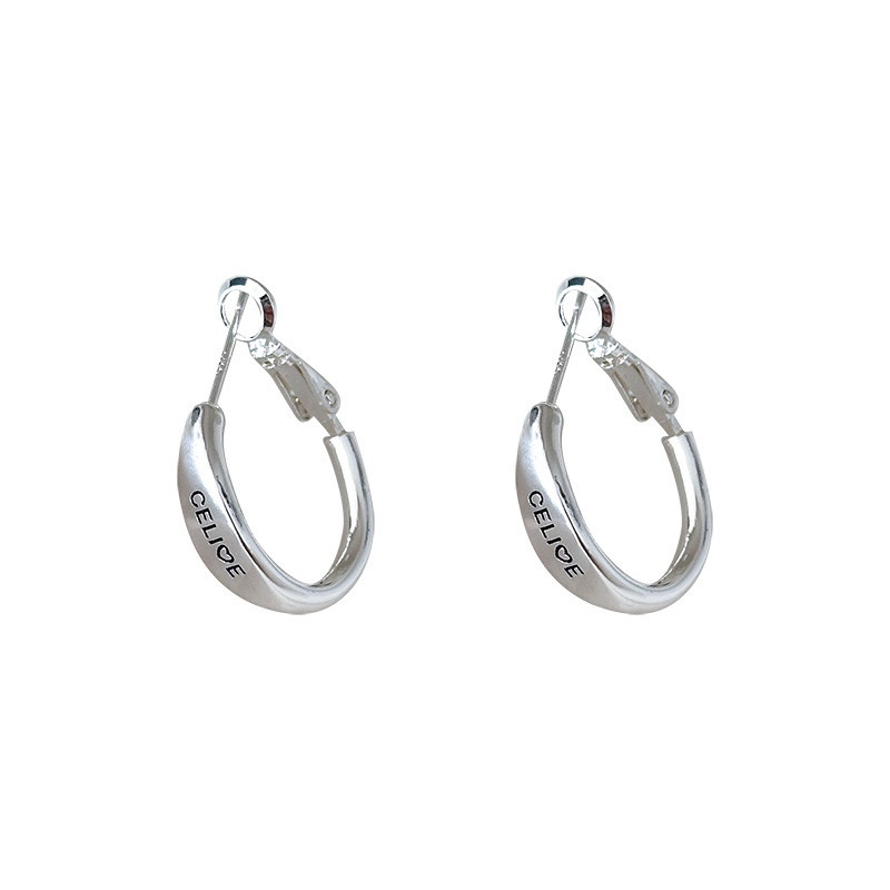 Silver tone hoop earrings with engraved lettering and hinged closure on white background