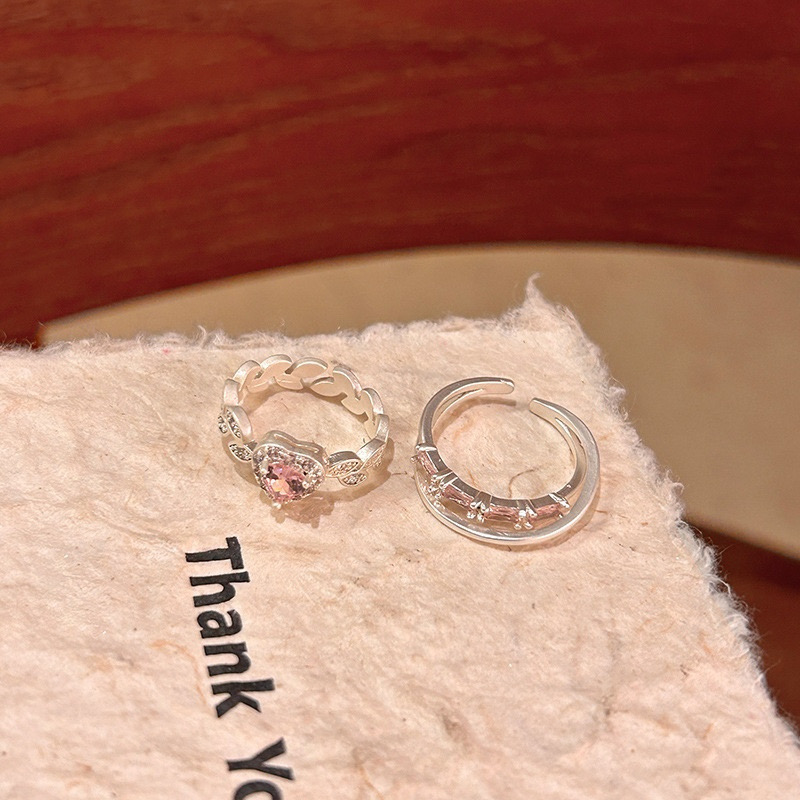 Two-piece silver ring set showing pink heart design and curved open band