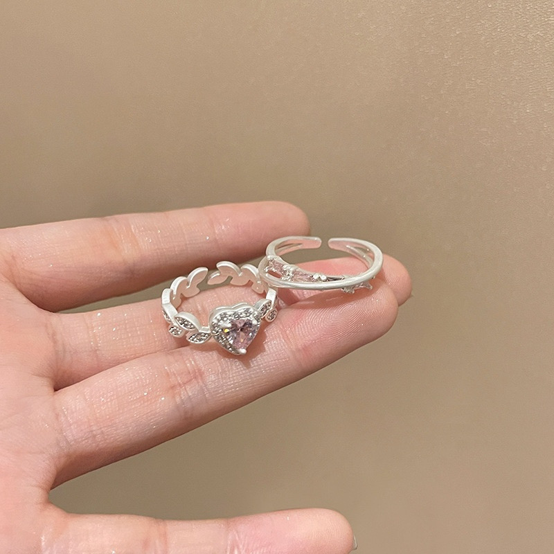 Silver 2-piece ring set with pink heart rhinestone ring and curved open ring displayed on fingers