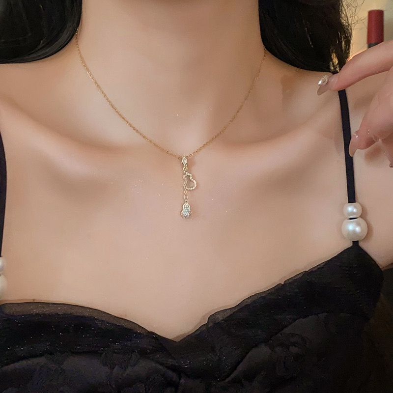 Gold-tone zircon gourd necklace worn with a black outfit showing the delicate pendant design