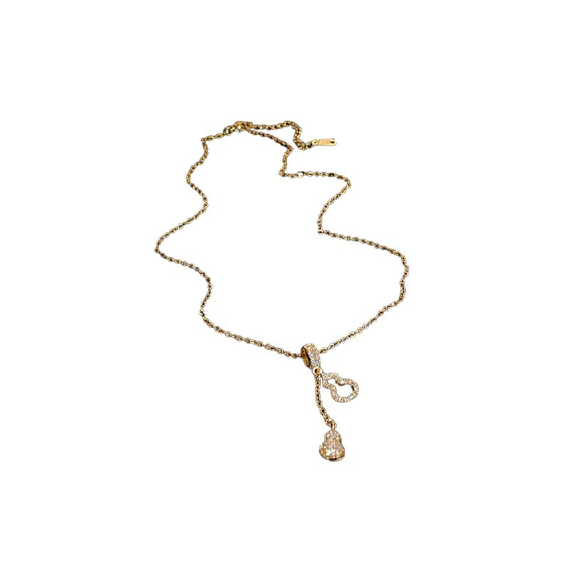 Gold zircon gourd pendant necklace with asymmetrical dangling charm on white background