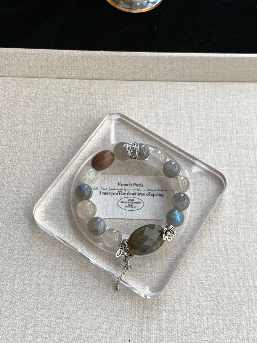 Moonstone and Rutilated Quartz bracelet resting in clear glass tray