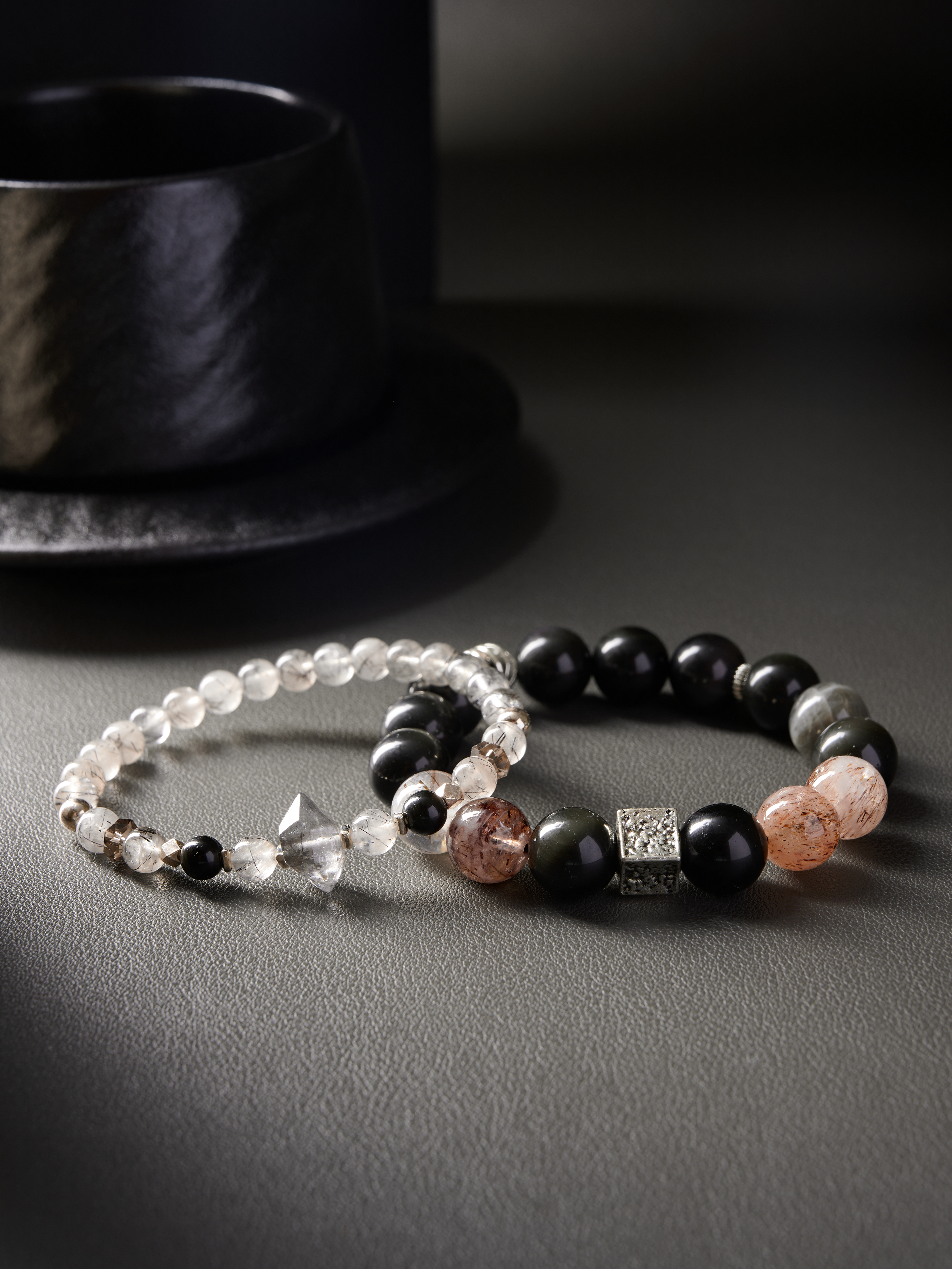 Pair of crystal bracelets side by side, top view showing rutilated quartz needles and polished obsidian beads