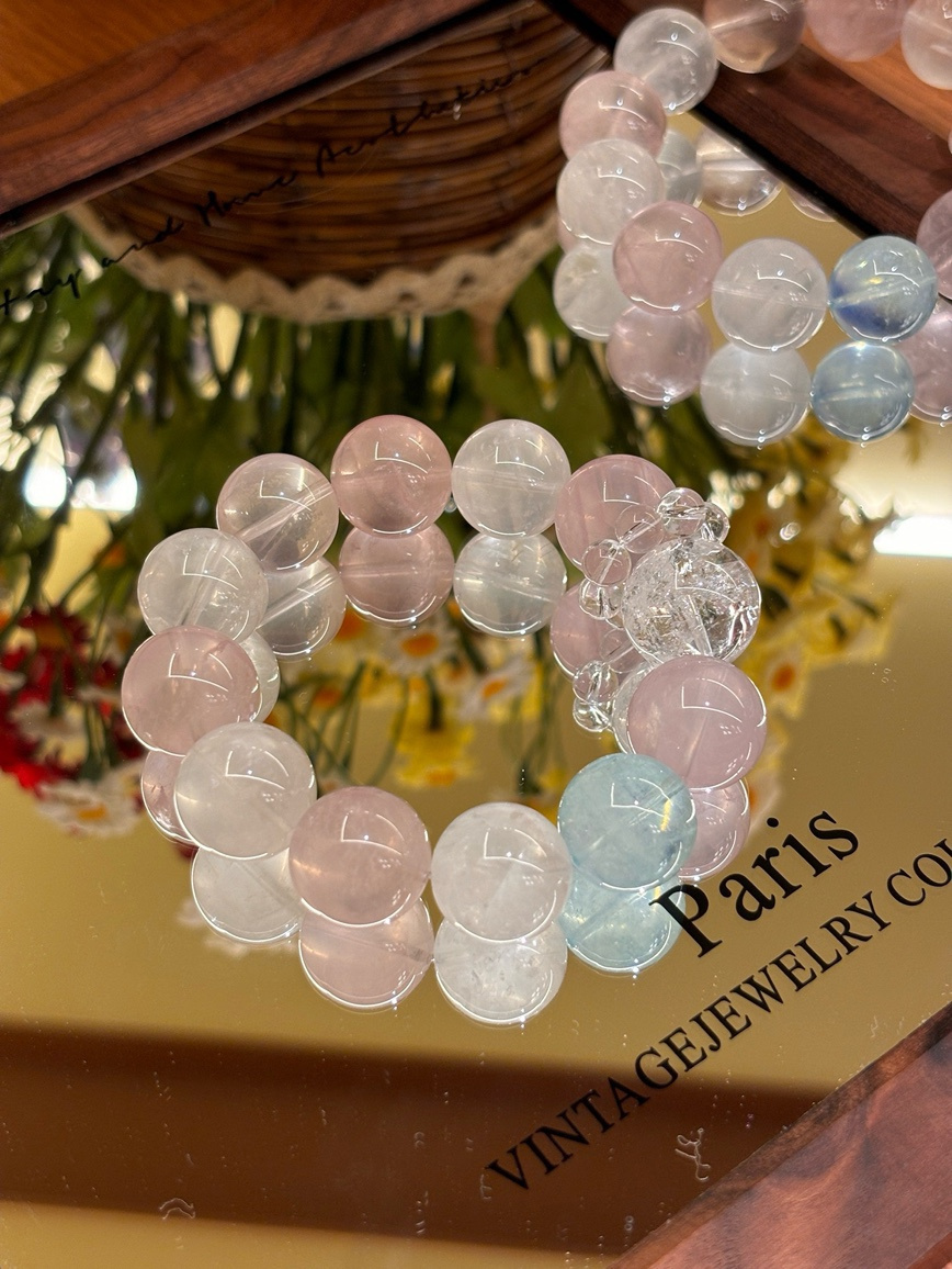 Rose Quartz, Clear Quartz, and Aquamarine bracelet displayed on a mirrored surface