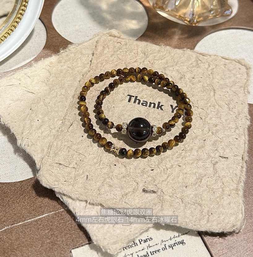 Handcrafted Tiger’s Eye and Obsidian double bracelet displayed on beige fabric card