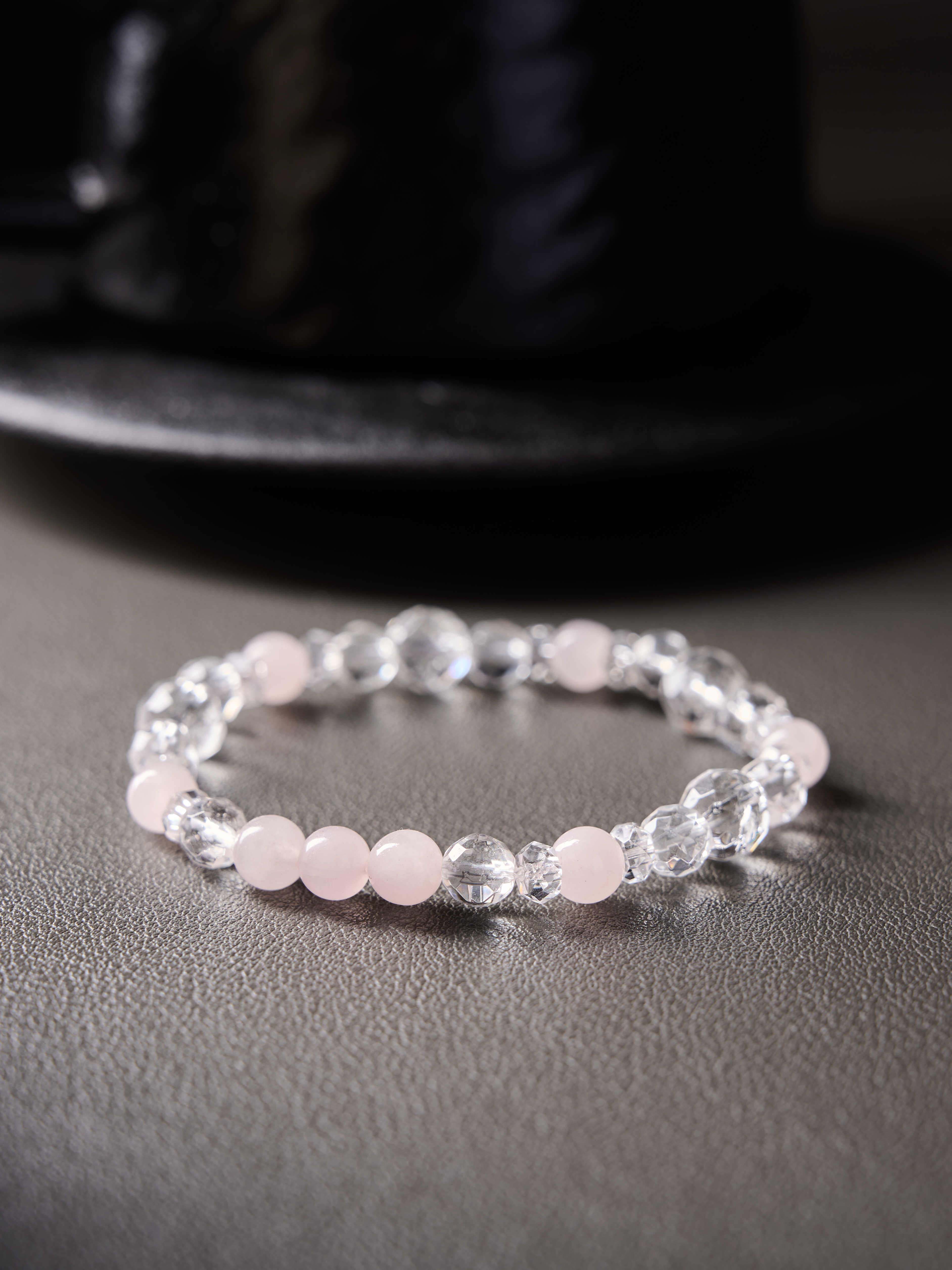 Flat lay circle showing soft blush rose quartz paired with transparent clear quartz beads