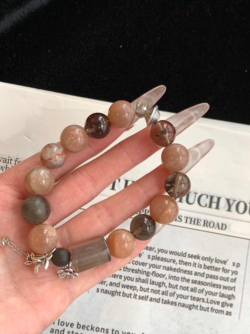 Close view of brown and white crystal beads with metal flower charm