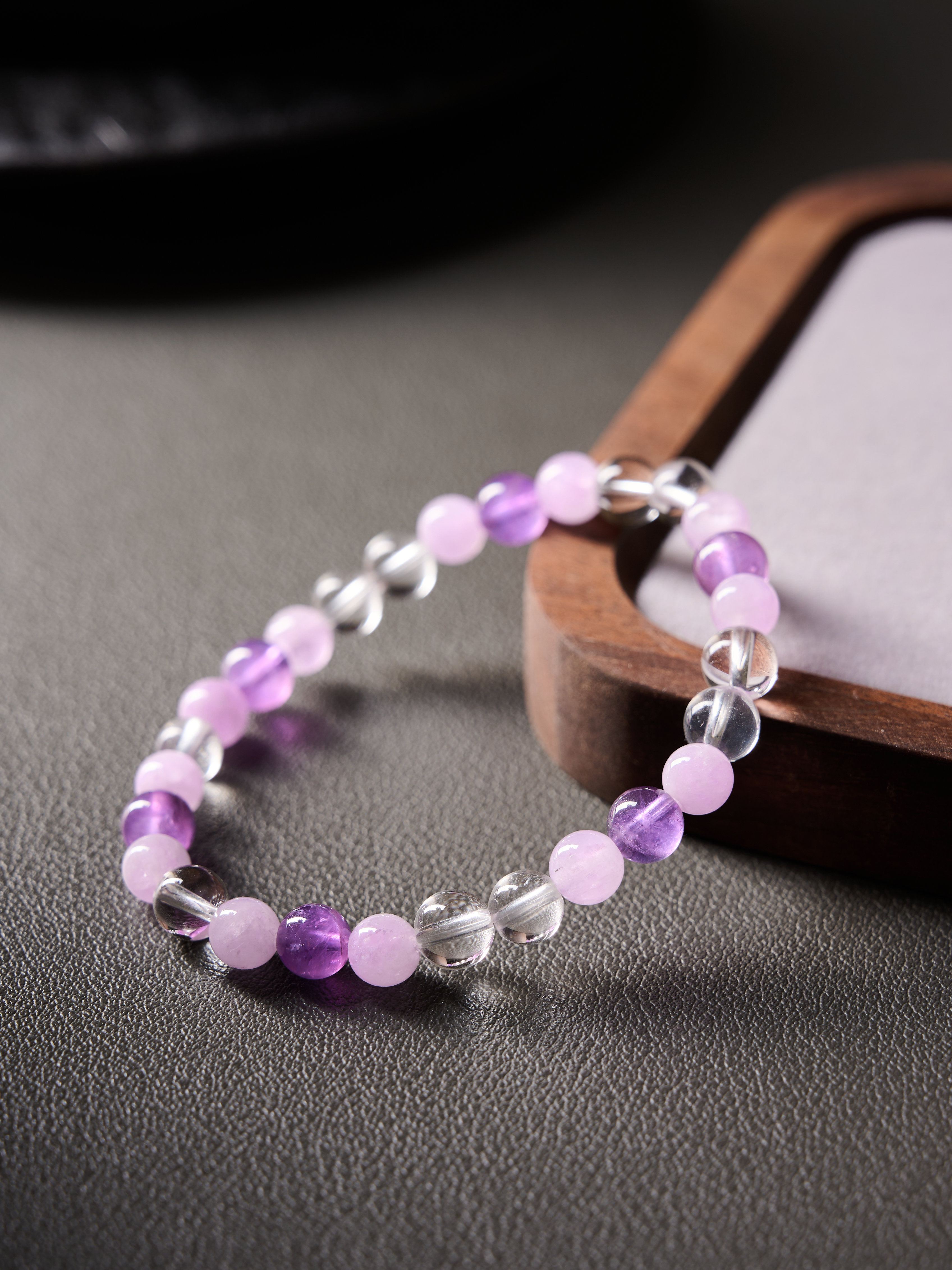 Macro side angle highlighting faceted clear quartz separators between smooth round beads
