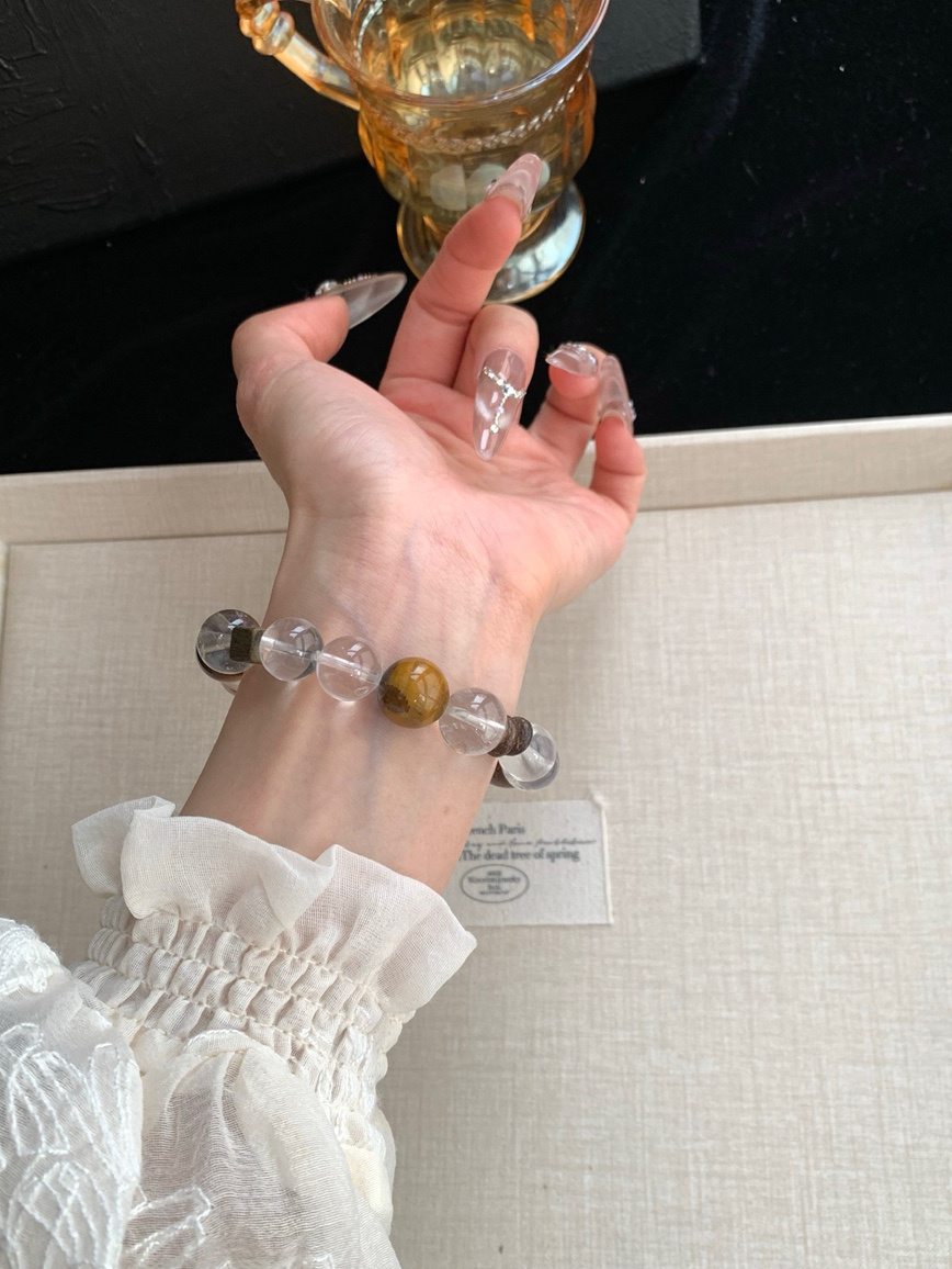 Wrist shot of Tiger’s Eye bracelet paired with white blouse