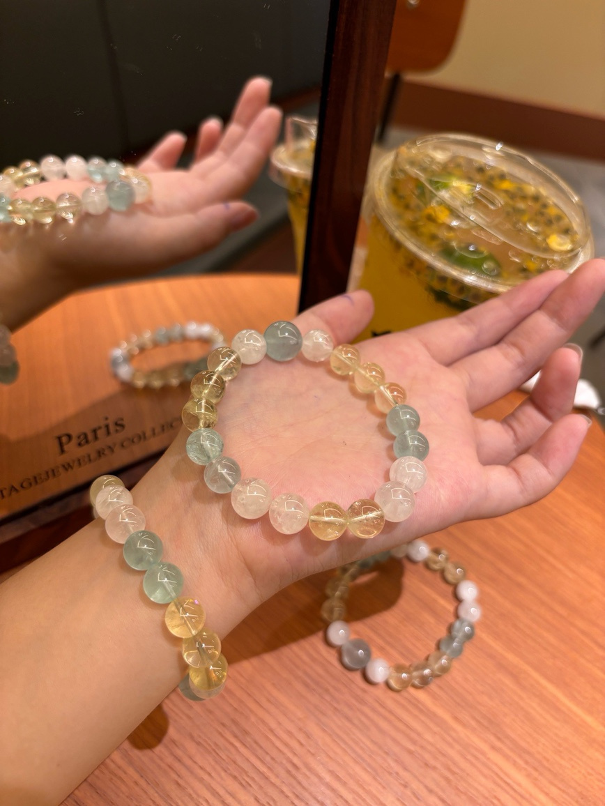Model wearing aquamarine and citrine crystal bracelet under warm light