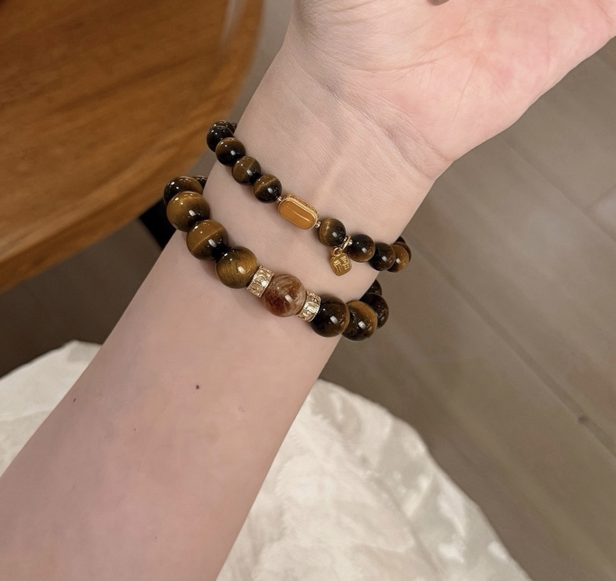 Tiger’s Eye and Smoky Quartz bracelets stacked on wrist under soft light