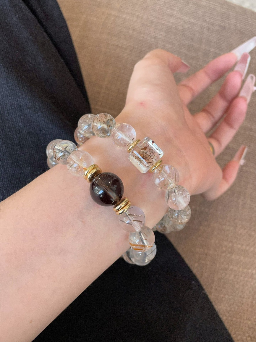 Model wearing rutilated quartz bracelet on wrist with gold accents