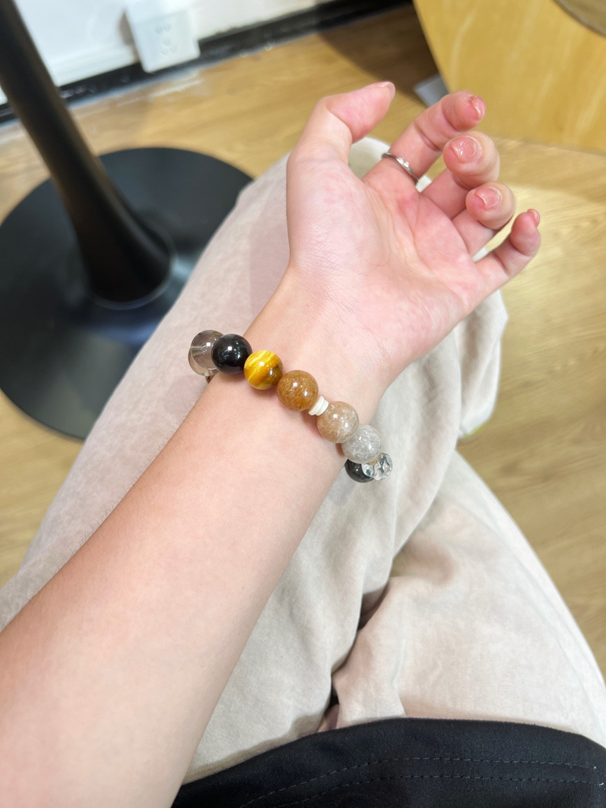 Model wearing tiger eye and citrine crystal bracelet on wrist