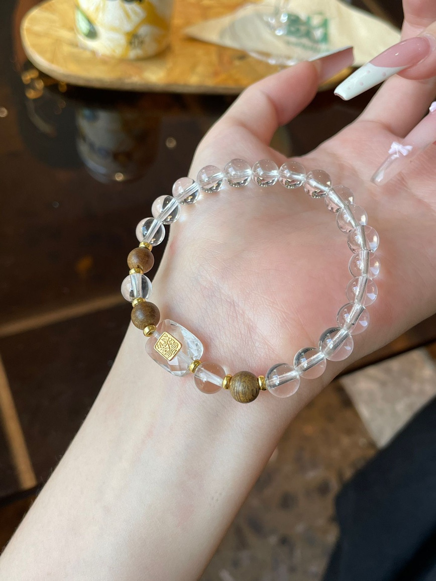 Worn view – bracelet on wrist under warm lighting, showing clarity and natural wood contrast.