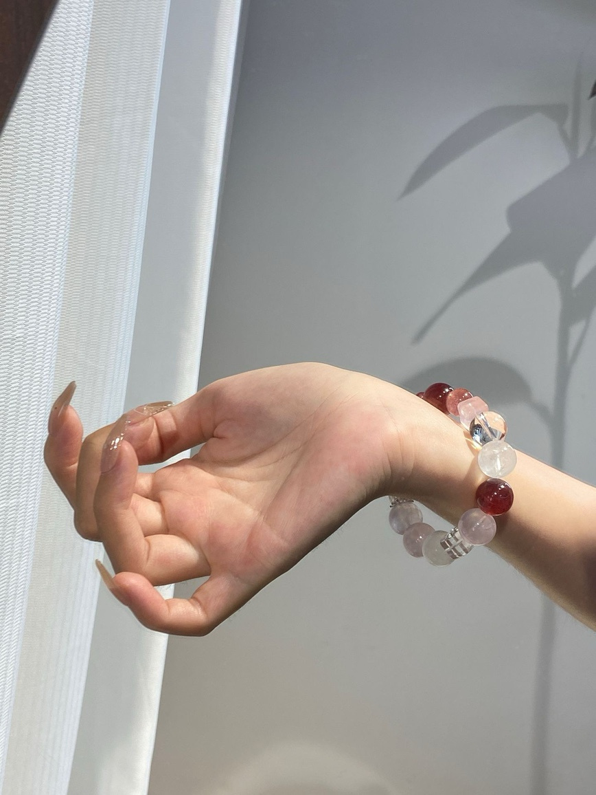 Model wearing strawberry quartz bracelet in sunlight