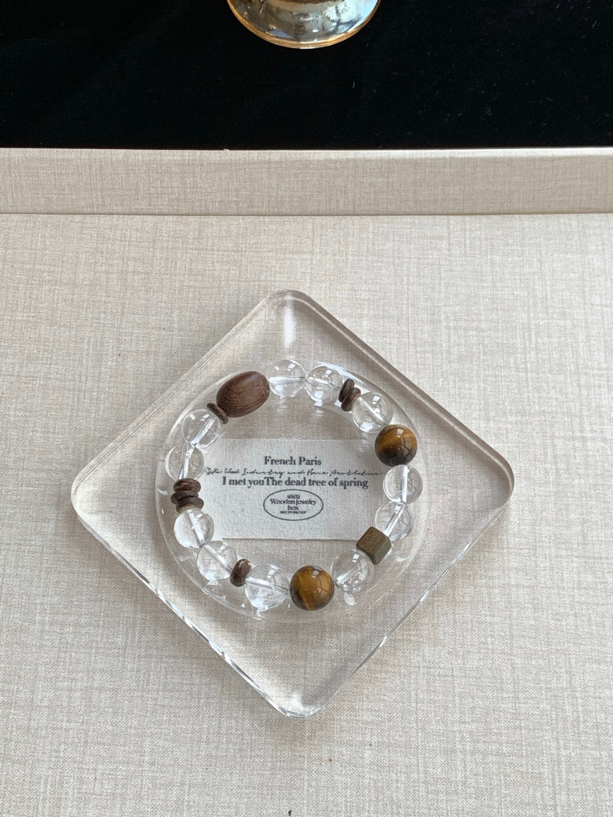 Clear Quartz and Tiger’s Eye bracelet resting in glass tray