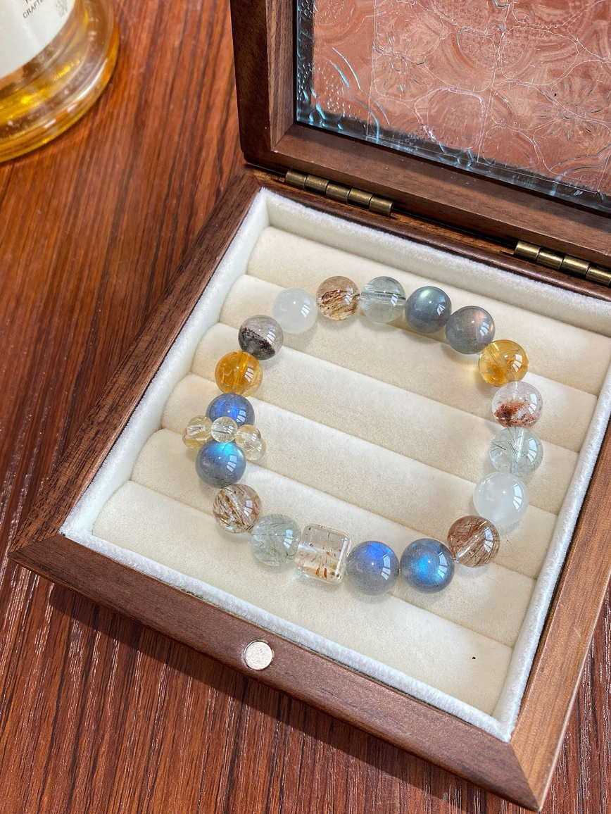 Main view – moonstone, citrine, green rutilated quartz, and black rutilated quartz bracelet in wooden jewelry box.