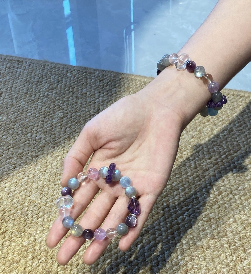Close-up of crystal bracelet with labeled stones including Amethyst and Labradorite