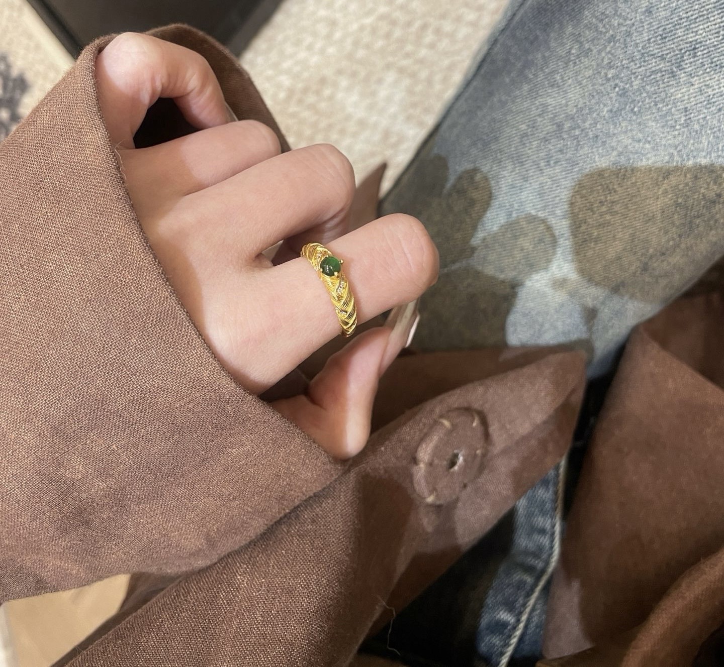 Close-up of green jade ring on hand with vintage outfit