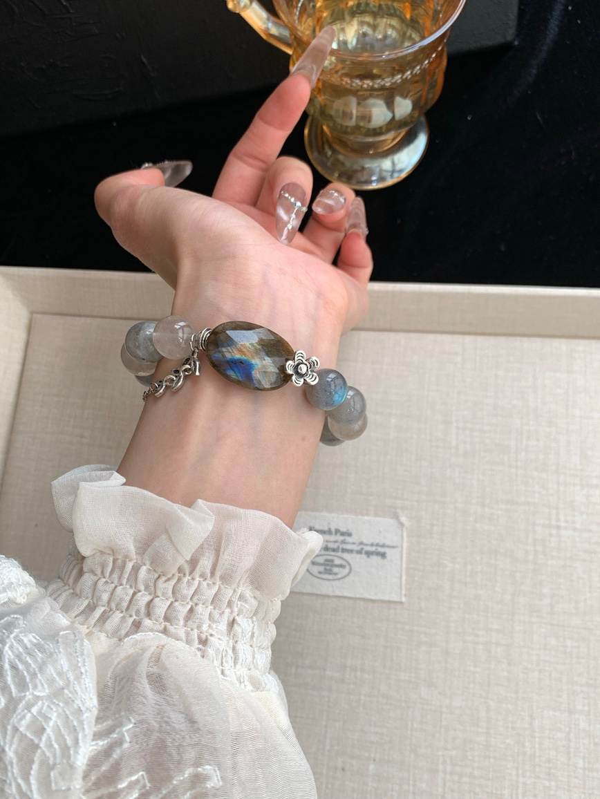 Wrist shot of Moonstone and Agarwood bracelet paired with white lace blouse