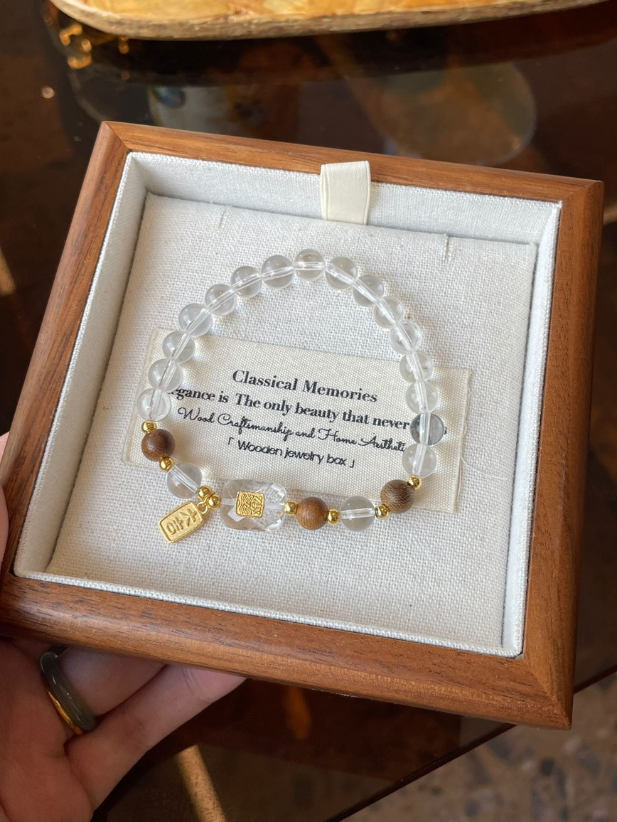 Main view – clear quartz and agarwood bracelet with gold accent in jewelry box.