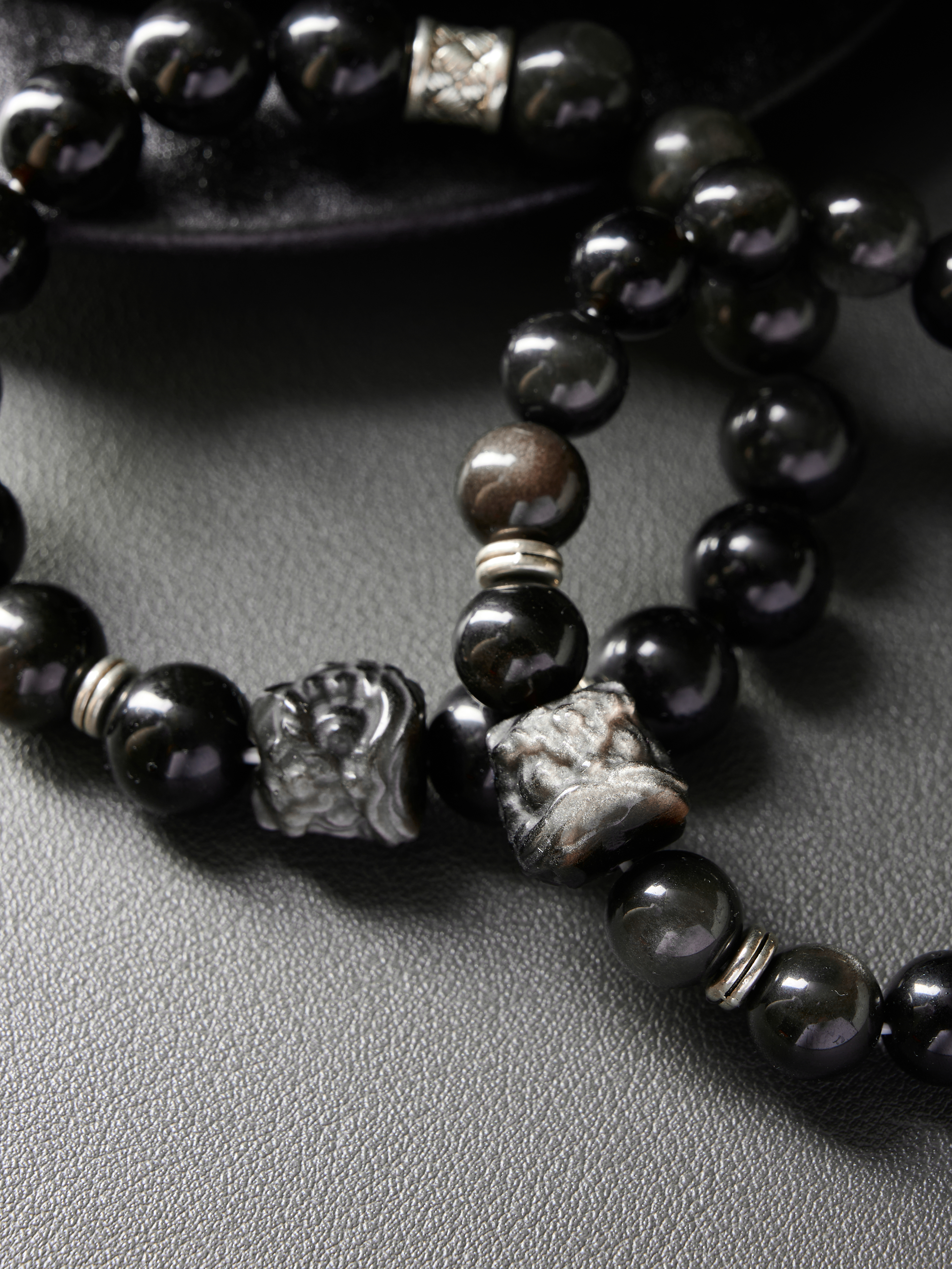 Extreme detail showing bead surface, elastic cord exit and spacer texture on the obsidian couple set