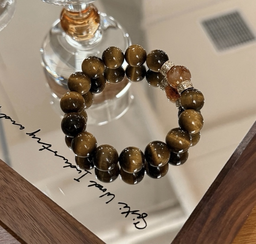 Handcrafted Tiger’s Eye bracelet displayed on mirror tray with golden accents