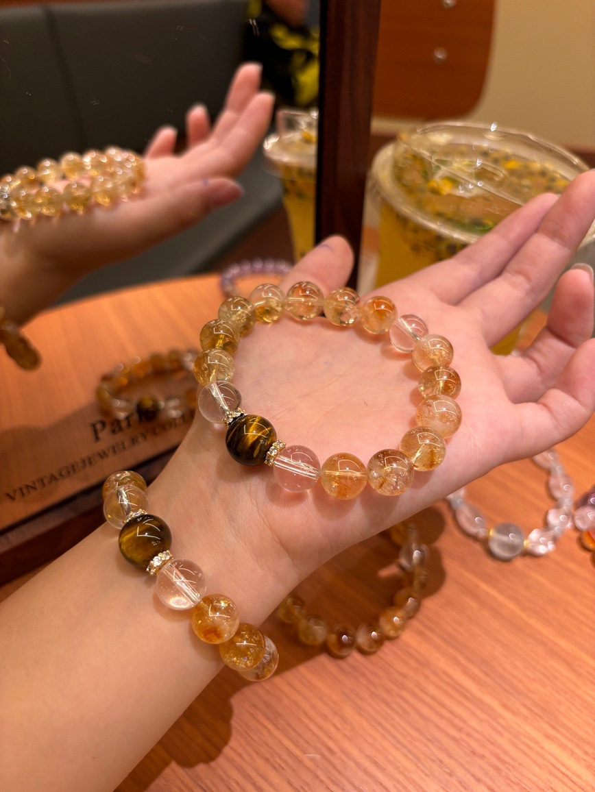 Model wearing citrine and tiger’s eye bracelet under warm light