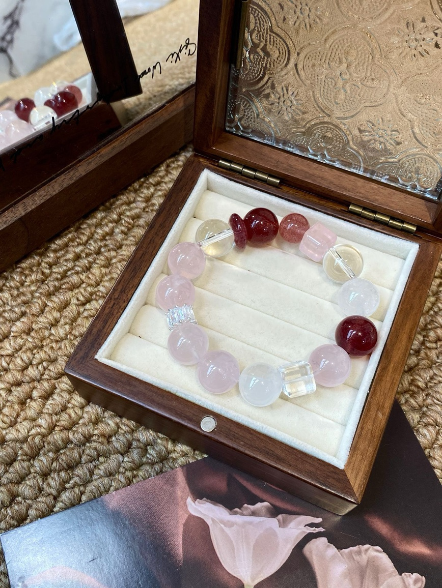 Strawberry Quartz and Rose Quartz bracelet displayed in a wooden jewelry box