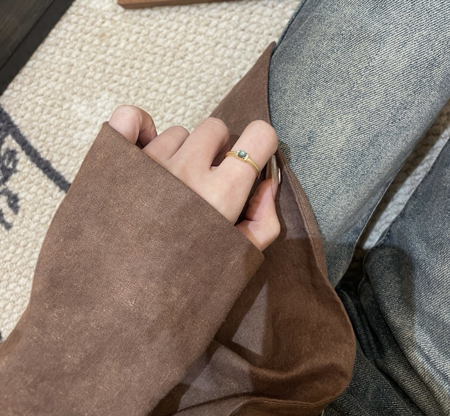 Adjustable jade ring worn with brown long-sleeve outfit