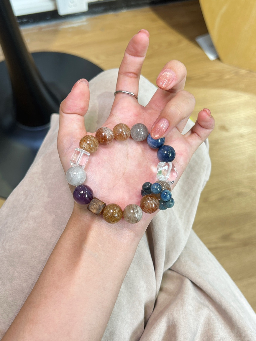 Model holding multi-stone crystal bracelet with kyanite and quartz accents