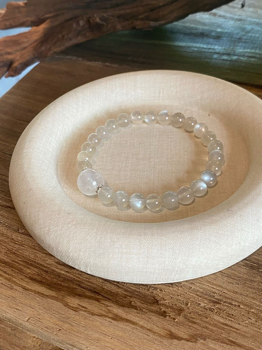 Flat lay – moonstone bracelet surrounded by soft decor for a calming aesthetic.