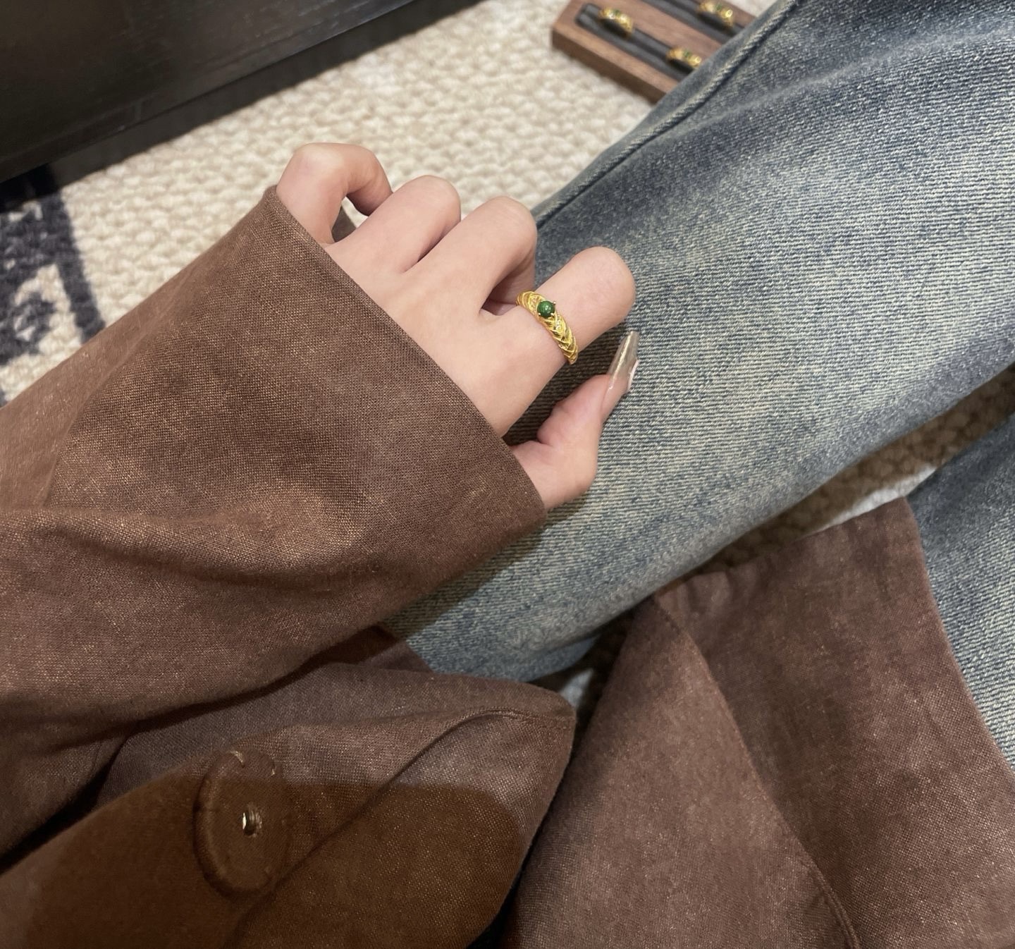 Model wearing minimalist jade ring on hand with soft sweater texture