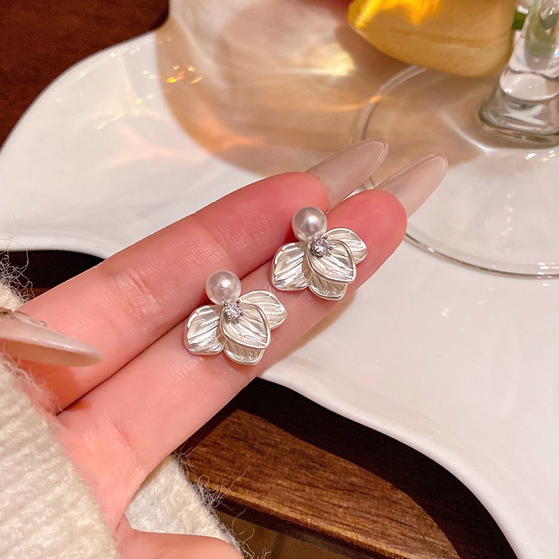 Floral faux pearl stud earrings hand-held detail