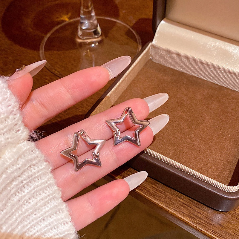 Silver geometric star earrings hand-held detail