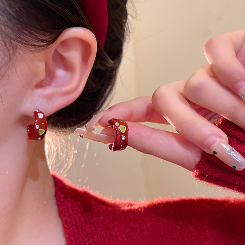 Red heart rhinestone hoop earrings worn on ear