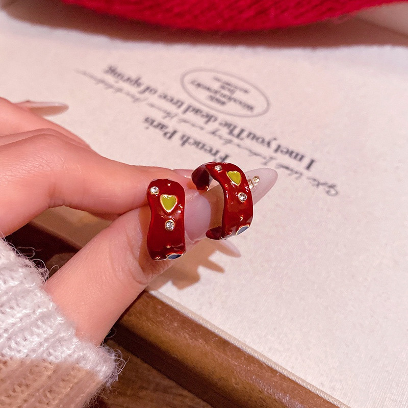Red multicolor heart hoop earrings held in hand