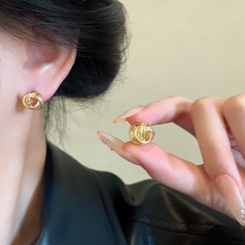 Gold and silver knot stud earrings lifestyle view