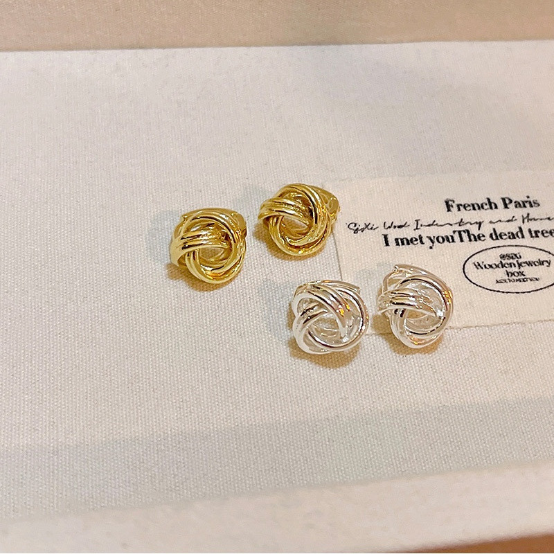 Gold and silver knot earrings in jewelry tray