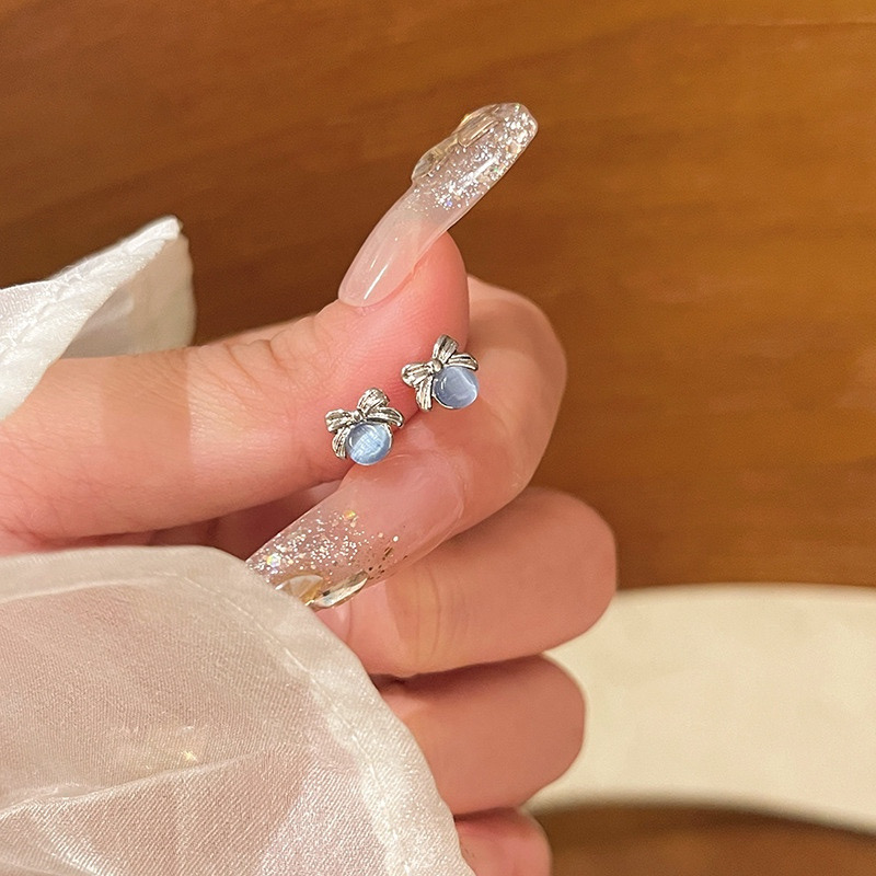 Blue cat eye bow earrings close-up