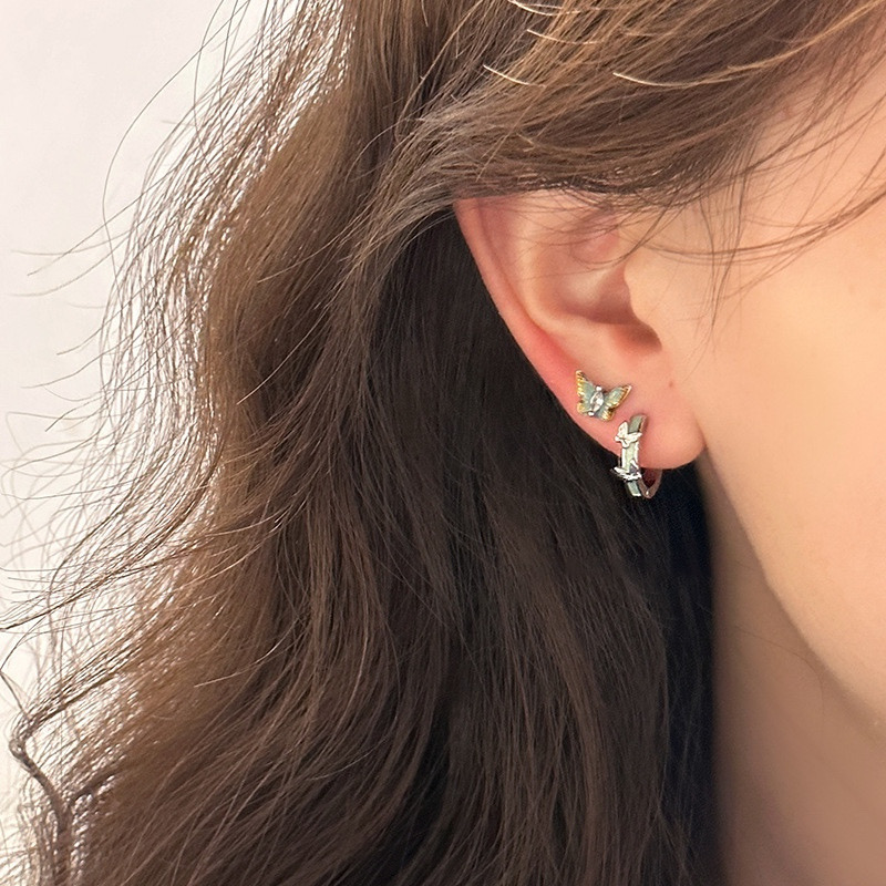 Silver butterfly hoop earrings worn on ear