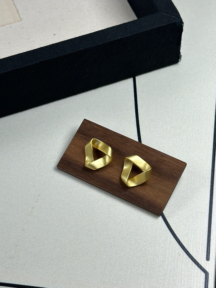 Gold twisted geometric earrings front view