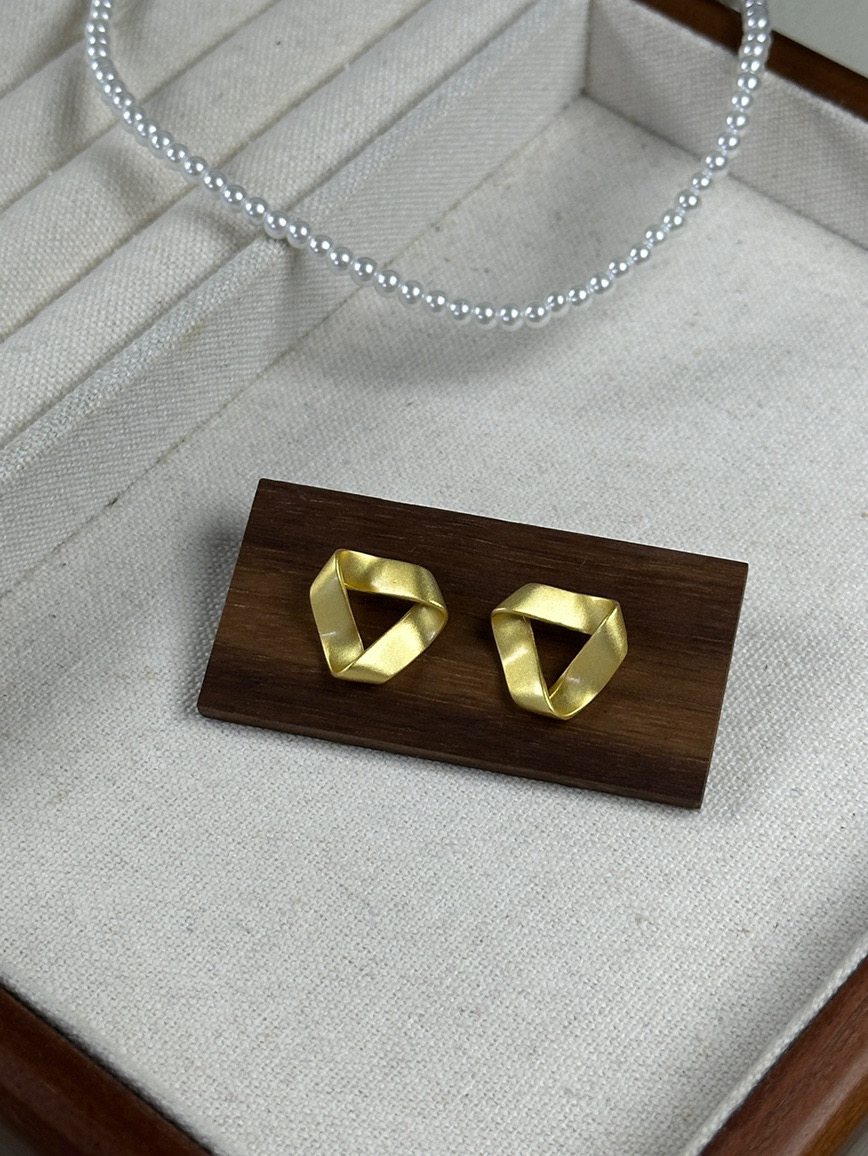 Gold sculptural geometric earrings display
