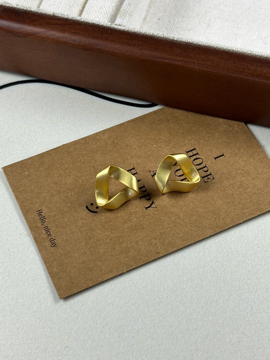 Gold twisted geometric earrings angled view