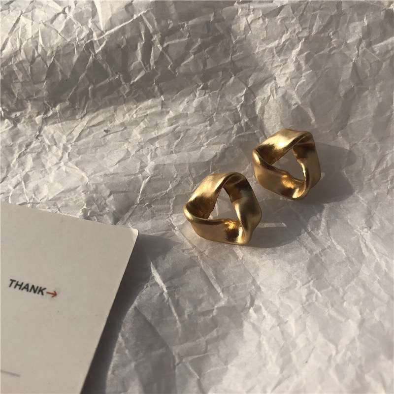 Gold geometric earrings in natural light