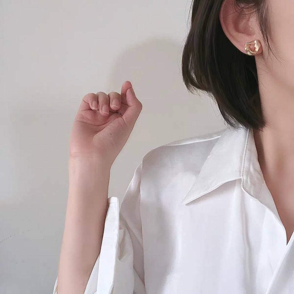 Gold geometric earrings styled on model