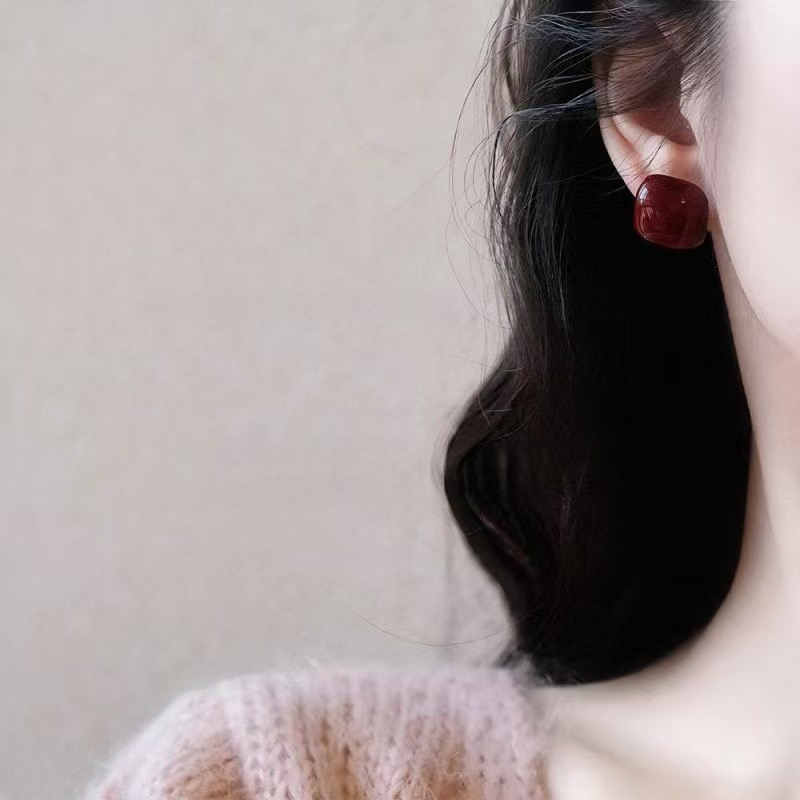 Burgundy square stud earrings on ear