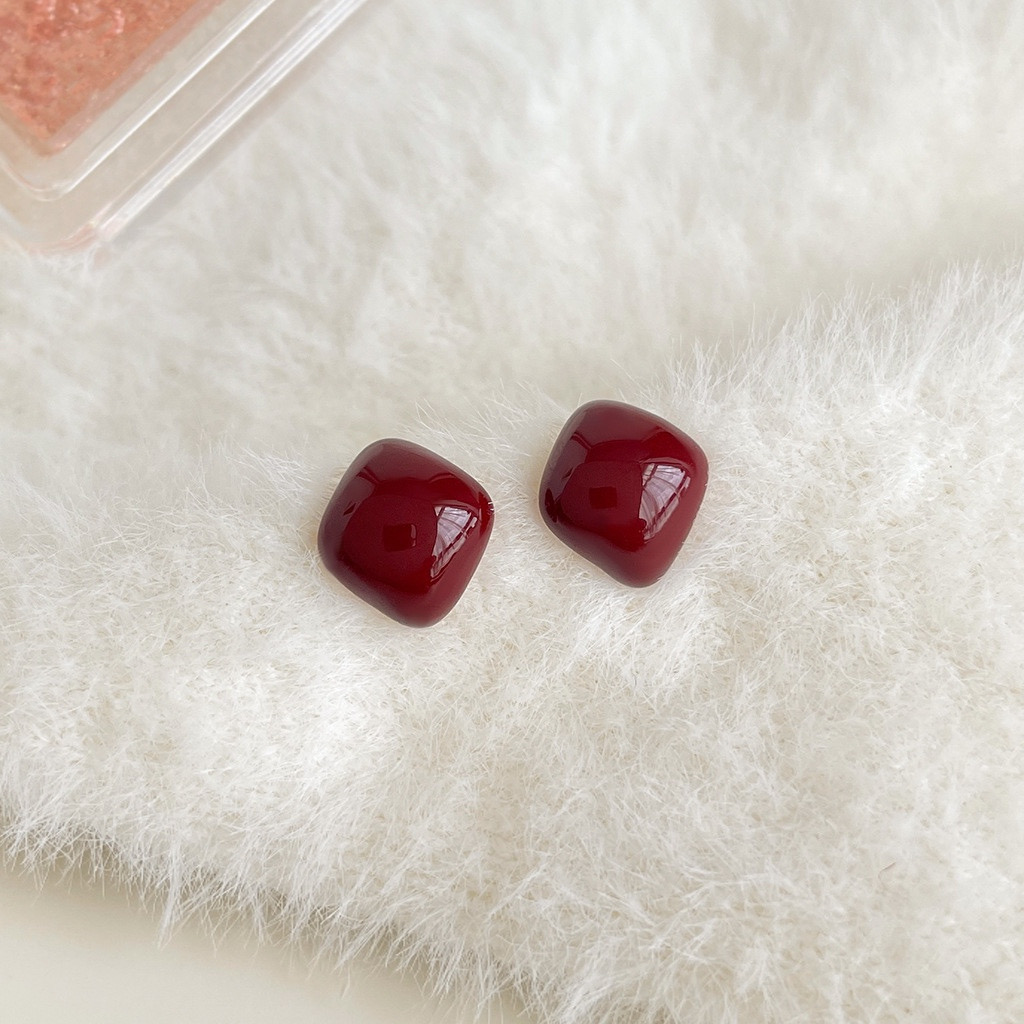 Burgundy enamel stud earrings close-up